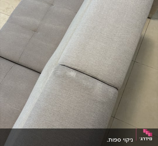 ספה אפורה עם ריפוד נקי על רצפת אריחים